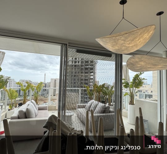 מרפסת עם צמחים ונוף עירוני ברקע